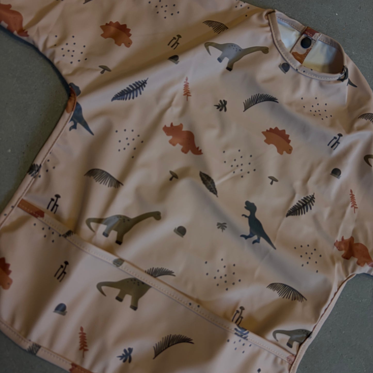 Waterproof slab met mouwen – verstelbaar (0–4 jaar) dino peach